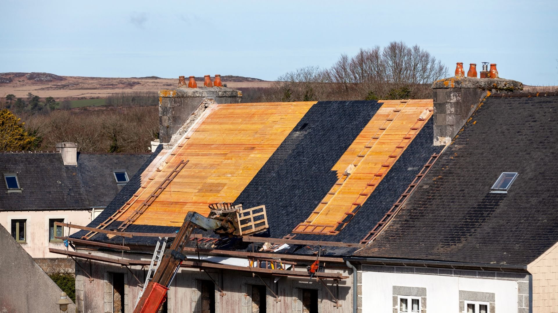 Roof repair with wooden planks and scaffolding in rural residential area