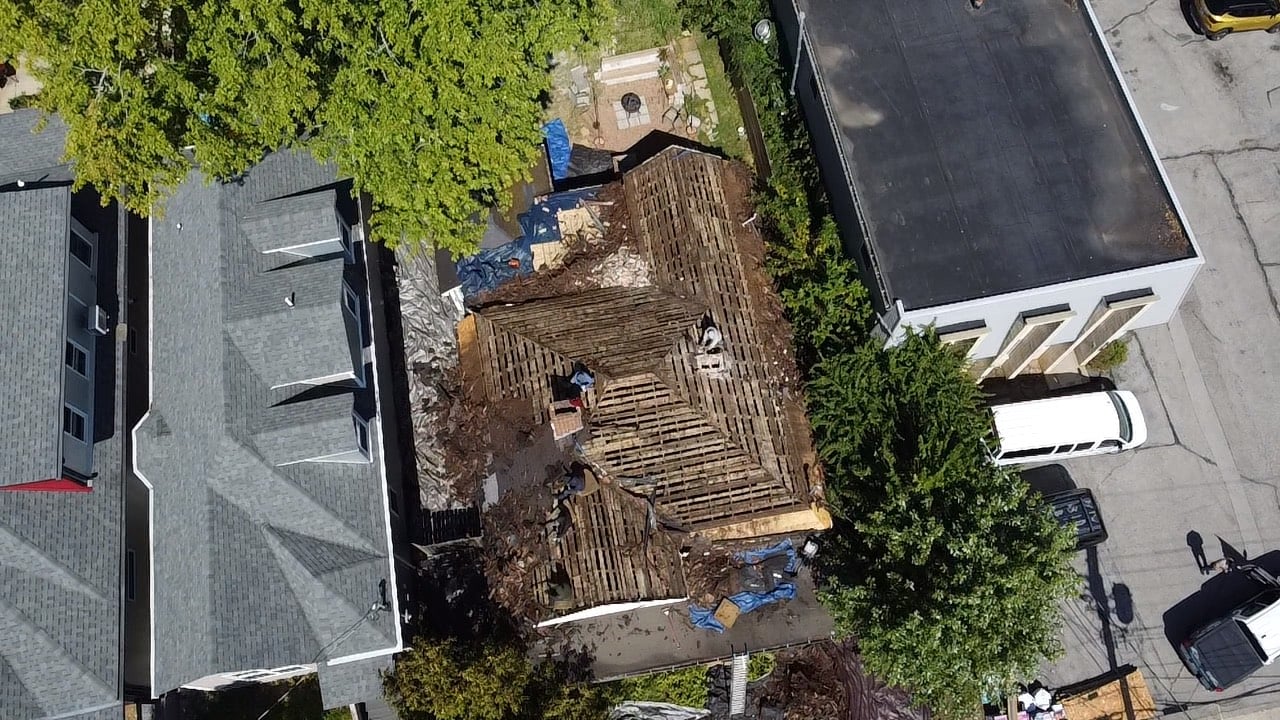 Aerial view of house roof under construction with wooden frame exposed